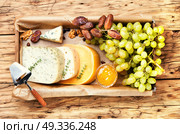 cheese and grapes. Cheese with coriander and grapes on retro wooden background. Стоковое фото, агентство Ingram Publishing / Фотобанк Лори