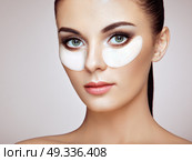 Portrait of Beauty Woman with Eye Patches. Woman Beauty Face with Mask under Eyes. Beautiful Female with natural Makeup and White Cosmetics Collagen Patches on Fresh Facial Skin. Стоковое фото, агентство Ingram Publishing / Фотобанк Лори