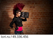 Young punk girl on brick wall background. Стоковое фото, агентство Ingram Publishing / Фотобанк Лори