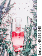 Perfume bottle with plants and flowers, top view. Perfumery, cosmetics, botanical fragrance concept. Стоковое фото, агентство Ingram Publishing / Фотобанк Лори