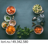 Food background with fresh diced vegetables , cooking spoon and glass jar, top view, frame. Healthy vegetarian food and cooking concept. Homemade lunch in jar making ingredients. Стоковое фото, агентство Ingram Publishing / Фотобанк Лори