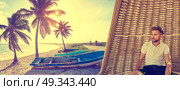 Young beard man in beach parasol at tropical beach in summer vacation photomount. Стоковое фото, агентство Ingram Publishing / Фотобанк Лори