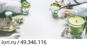 Green spa or wellness background with towels, candle, orchid flowers and body and face care tools and accessories on white desktop, top view with copy space, frame. Стоковое фото, агентство Ingram Publishing / Фотобанк Лори