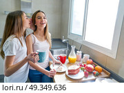best friends girls teens breakfast in kitchen. best friends girls teens breakfast in kitchen whispering ear. Стоковое фото, агентство Ingram Publishing / Фотобанк Лори