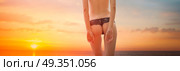 woman in a swimsuit is standing ass at sunset. woman in a swimsuit is standing ass. Стоковое фото, агентство Ingram Publishing / Фотобанк Лори