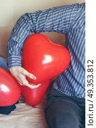 Man holding a red heart shaped balloon . Стоковое фото, агентство Ingram Publishing / Фотобанк Лори