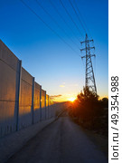 Sunset in a track with electric tower and concrete. Sunset in a track with electric tower and concrete wall. Стоковое фото, агентство Ingram Publishing / Фотобанк Лори