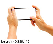 WARSAW, POLAND - DECEMBER 02, 2017: Two hands holding new Iphone X mobile phone over white background. New Iphone X. New Iphone X. Редакционное фото, агентство Ingram Publishing / Фотобанк Лори