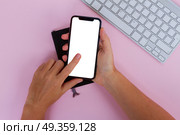 WARSAW, POLAND - DECEMBER 02, 2017: Two hands holding and touching New Iphone X mobile phone with colorful apps icons. New Iphone X. New Iphone X. Редакционное фото, агентство Ingram Publishing / Фотобанк Лори