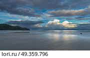 Morning by the ocean. The clouds in the blue sky are highlighted in gold. Glare on the water. The waves spread over a wide sandy beach. Reflection on wet sand. Malaysia. Borneo. Kota Kinabalu. Стоковое фото, фотограф Вера Ивановна Кубарева / Фотобанк Лори