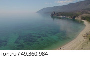 Sandy bay on a summer day. Beautiful view of Cape Kolokolny, sandy beach, clear water of Lake Baikal. Drone flight over sandy beach. Стоковое видео, видеограф Виктория Тельминова / Фотобанк Лори
