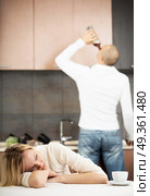 The upset wife against the drunk husband on kitchen. Household alcoholism. Стоковое фото, агентство Ingram Publishing / Фотобанк Лори