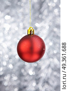 Red Christmas-tree decoration on a silvery background. Attribute of Christmas. Стоковое фото, агентство Ingram Publishing / Фотобанк Лори