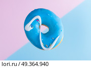 flying doughnuts on blue. one falling sweet doughnut on blue and pink background. Стоковое фото, агентство Ingram Publishing / Фотобанк Лори