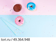 flying doughnuts on blue. Two sweet doughnuts with cacao on blue and pink background with copy space. Стоковое фото, агентство Ingram Publishing / Фотобанк Лори