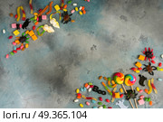 Colorful halloween candies on stone. Trick and treat - colorful halloween candies frame on gray stone background with copy space. Стоковое фото, агентство Ingram Publishing / Фотобанк Лори
