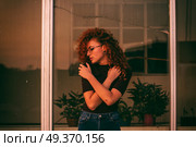 Young redhead woman hugging herself in a summer day at sunset . Стоковое фото, агентство Ingram Publishing / Фотобанк Лори