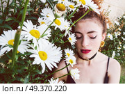 Young redhead woman surrounded by daisies . Стоковое фото, агентство Ingram Publishing / Фотобанк Лори