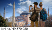 couple of travelers make a photo on a smartphone on the background of Istanbul. Hagia Sophia . Стоковое фото, агентство Ingram Publishing / Фотобанк Лори