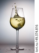 Hight glass of white wine with splash from ice. Glass of white wine. Стоковое фото, агентство Ingram Publishing / Фотобанк Лори