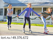 Teen girls group rolling skate in the street outdoor. Стоковое фото, агентство Ingram Publishing / Фотобанк Лори