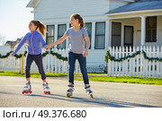 Teen girls group rolling skate in the street outdoor. Стоковое фото, агентство Ingram Publishing / Фотобанк Лори