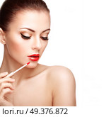 Beautiful Young Woman Paints Lips with Lipstick. Perfect Make-up. Beauty Fashion. Perfect Skin. Стоковое фото, агентство Ingram Publishing / Фотобанк Лори