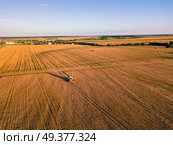 Harvester machine working in field. Combine machine harvesting agriculture golden ripe wheat field. Aerial view on the combine working on large rye field near Minsk, Belarus. Стоковое фото, агентство Ingram Publishing / Фотобанк Лори