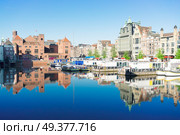 Amsterdam canal Damrak with typical dutch houses and boats at morning blue hour, Holland, Netherlands.. Houses of Amsterdam, Netherlands. Стоковое фото, агентство Ingram Publishing / Фотобанк Лори