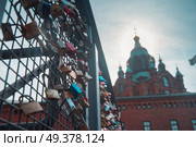 Hanging locks on the bridge on the background of the Uspensky Cathedral of Helsinki. Стоковое фото, агентство Ingram Publishing / Фотобанк Лори