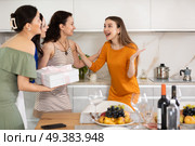 Three women have arrived for birthday celebration and presenting gift to birthday woman. Стоковое фото, фотограф Яков Филимонов / Фотобанк Лори