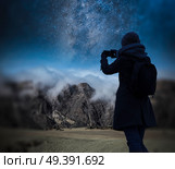 the girl is taking pictures of the starry night sky over the mountains. Astrophotography. Стоковое фото, агентство Ingram Publishing / Фотобанк Лори