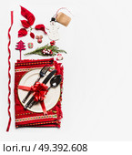 Christmas concept. Various holiday objects: table place setting with cutlery and decorations, fir branches, snowman, cones, tags, ribbon and poinsettia on white background. Flat lay, top view. Стоковое фото, агентство Ingram Publishing / Фотобанк Лори