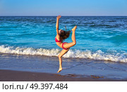 acrobatic gymnastics bikini girl in a beach blue shore at summer. Стоковое фото, агентство Ingram Publishing / Фотобанк Лори