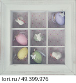 Easter tic tac toe game with eggs and rabbits in box clos eup - pastel colors and rustic style, retro toned. Easter eggs in box. Стоковое фото, агентство Ingram Publishing / Фотобанк Лори