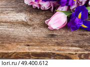 Blue irises and pik tulips on wooden aged background with copy space. Blue irises and pik tulips. Стоковое фото, агентство Ingram Publishing / Фотобанк Лори