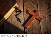Christian cross on wood bible and rosary beads over wooden vintage background. Стоковое фото, агентство Ingram Publishing / Фотобанк Лори