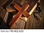 Christian cross on wood bible and rosary beads over wooden vintage background. Стоковое фото, агентство Ingram Publishing / Фотобанк Лори