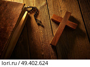 Christian cross on wood bible and rosary beads over wooden vintage background. Стоковое фото, агентство Ingram Publishing / Фотобанк Лори