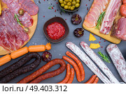 spanish tapas with pancetta, salami, chorizo, lomo, jamon with red hol salsa sause and olives, picnic table, top view. Picnic table with spanish sausage tapas. Стоковое фото, агентство Ingram Publishing / Фотобанк Лори