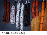 Cured meat and sausages hanging a rack at market.. Cured meat and sausages. Стоковое фото, агентство Ingram Publishing / Фотобанк Лори