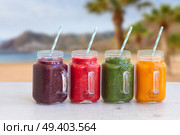 Colorful smoothy drinks in glass jars on white table. Fresh smoothy drink. Стоковое фото, агентство Ingram Publishing / Фотобанк Лори