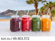 Colorful smoothy drinks in glass jars on white table. Fresh smoothy drink. Стоковое фото, агентство Ingram Publishing / Фотобанк Лори