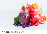 Colorful fresh smoothy drinks in glass jars with igredients on white table. Fresh smoothy drink with igredients. Стоковое фото, агентство Ingram Publishing / Фотобанк Лори