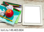 Apple with school supplies and tablet with empty screen on white wooden table, top view. Apple with school supplies. Стоковое фото, агентство Ingram Publishing / Фотобанк Лори