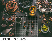 Homemade chocolate pralines preparation on dark rustic table background with vintage kitchen utensils and ingredients. Prunes stuffed with nuts and melting chocolate, top view. Стоковое фото, агентство Ingram Publishing / Фотобанк Лори