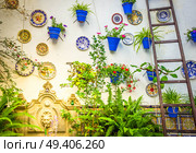 typical andalusian wall decorated with plates and flower pots , Cordoba, Spain, toned. patio decarated wall. Стоковое фото, агентство Ingram Publishing / Фотобанк Лори