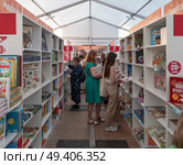 Люди знакомятся с книжными новинками на книжном фестивале на Красной площади в Москве. Редакционное фото, фотограф Галина Эмберг / Фотобанк Лори