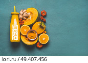 Bottle with healthy energetic drink and word smoothie, for cold season with orange ingredients : pumpkin, persimmon , orange fruits, ginger and turmeric or curcuma powder , top view. Стоковое фото, агентство Ingram Publishing / Фотобанк Лори