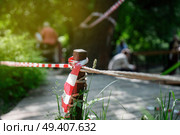 People ignoring safety rules by crossing the red-white barrier tape, demonstrating violation of established regulations. Стоковое фото, фотограф Татьяна Степанищева / Фотобанк Лори